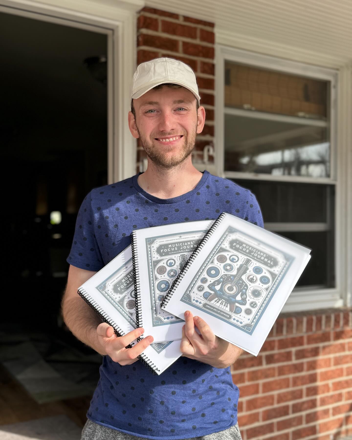 Jordan Lovinger holding copies of the Musician's Focus Journal
